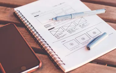 Ein Zeichenblock auf dem ein Wireframe eines Interfaces zu sehen ist